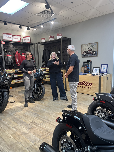 Marie-Ève Dicaire, Lulu Hughes et le chroniqueur moto Jean Paré discutent des motos Indian Motorcycle chez Mathias Sports.